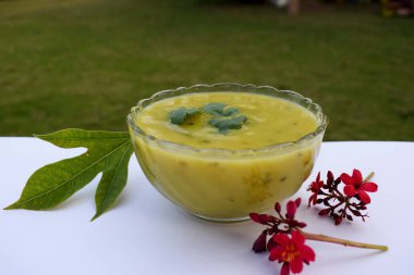 Fafda ki Kadhi chutney made of gramflour served with gujarati snacks of faafda and ganthiya garnished with coriander leaf. delicious dip served with bhajia in gujarati cuisine clipart