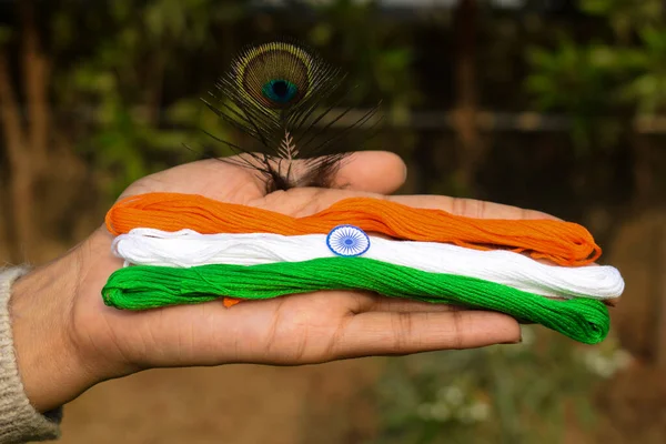 Indian flag tricolor tiranga saffron, white and green embroidery threads.Girl palm holding embroidered thread as concept for Indian republic day celebration as fashion depicting concept of freedom