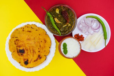 Indian popular dish makki di roti and Sarson da saag, mustard leaves curry and unleavened maize flour bread served in an authentic way with white butter and green chilly. Punjabi traditional style food clipart