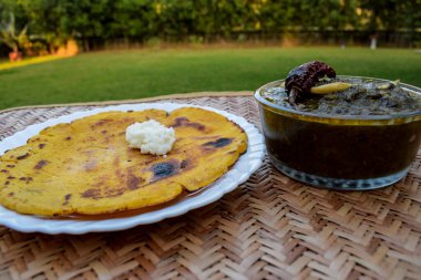 Makki di roti ve Sarson da saag 'in yan görüntüsü, hardal yaprakları köri ve mayasız mısır unu ekmeği otantik bir şekilde servis edilir. Punjabi tarzı geleneksel yemekler.