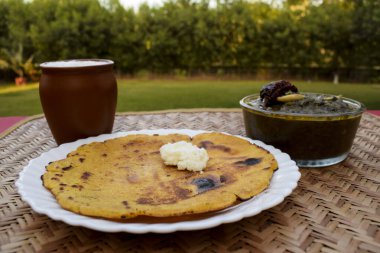 Makki di roti ve Sarson da saag 'in yan görüntüsü, hardal yaprakları köri ve mayasız mısır unu ekmeği otantik bir şekilde servis edilir. Punjabi tarzı geleneksel yemekler.