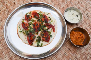 Uttapa, Hindistan 'da Uttapa olarak da bilinen bir kreptir. Dilimlenmiş domates, kişniş ve soğan. Bu beyaz hindistan cevizi soslu ve kırmızı zencefil soslu domates uttapam.