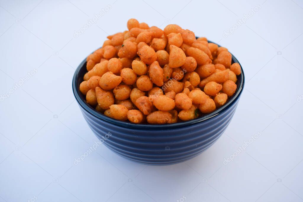 Indian famous namkeer snack Kara boondi or spicy salty boondi served in transparent bowl. Tea time snack fried chickpea floour or besan deep fried in oil. Tasty crunchy yummy homemade festival snack