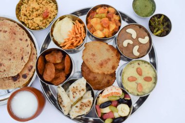 Hint mutfağı Upwas Thali complere meal for vrat ekadashi. Upawas thali meal with Rajgira puri, paratha, shakarkand halwa, alu sabji, amaranth sheera pakoda, sabudana ata dhokla, chips