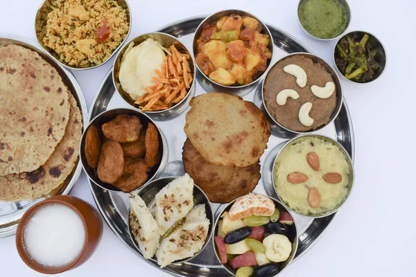 Hint mutfağı Upwas Thali complere meal for vrat ekadashi. Upawas thali meal with Rajgira puri, paratha, shakarkand halwa, alu sabji, amaranth sheera pakoda, sabudana ata dhokla, chips