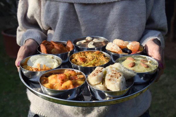 Geleneksel Farali Hint yemekleri thali 'de servis edilir ve upawaas upwas ya da vrat ka khana için birçok öğe ile kâselerde servis edilir. Hindistan 'da oruç günleri için çiçek yapraklarıyla süslenmiş. Kadın Hint Thaali 'sine hizmet ediyor.