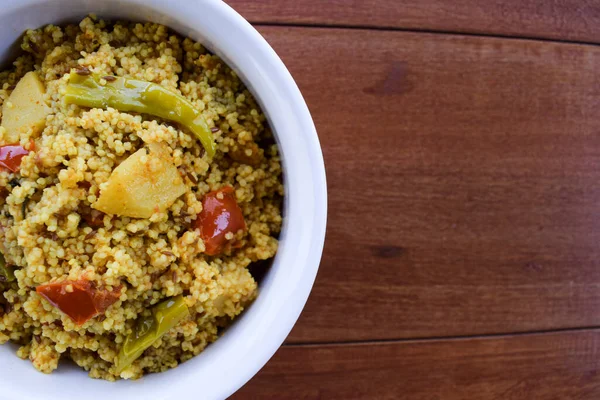 Traditional Indian fasting food recipe dish called Bhagar homemade of Barnyad millet rice grains. Also known as samo or sama pulao rice khichdi. Indian fasting food dish on wooden background