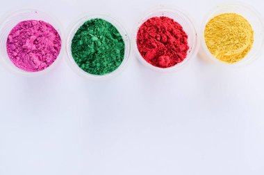 Hint Holi festivallerinde kullanılan kasedeki organik renkler. Holi renkli tozlar canlı pembe, kırmızı, gren ve sarı. Yazı tipi yazmak için beyaz arkaplan boşluğu. Holi temalı duvar kağıdı posterleri