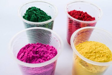 Hint Holi festivallerinde kullanılan kasedeki organik renkler. Holi renkli tozlar canlı pembe, kırmızı, gren ve sarı. Yazı tipi yazmak için beyaz arkaplan boşluğu. Holi temalı duvar kağıdı posterleri