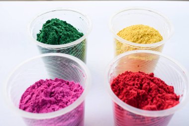 Hint Holi festivallerinde kullanılan kasedeki organik renkler. Holi renkli tozlar canlı pembe, kırmızı, gren ve sarı. Yazı tipi yazmak için beyaz arkaplan boşluğu. Holi temalı duvar kağıdı posterleri