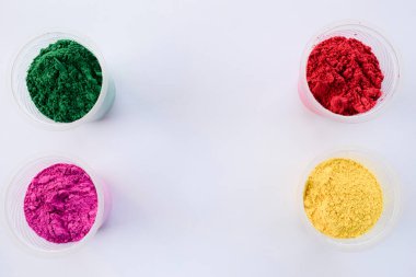 Hint Holi festivallerinde kullanılan kasedeki organik renkler. Holi renkli tozlar canlı pembe, kırmızı, gren ve sarı. Yazı tipi yazmak için beyaz arkaplan boşluğu. Holi temalı duvar kağıdı posterleri