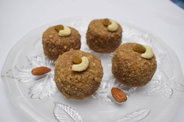 Laddu 'ya yakın çekim ya da ladoo buğday unundan yapılmış ve festivalde Ganesh chaturthi prasad gibi tabakta servis edilen tereyağlı ghee, kuru meyveli fındık ve beyaz badem ile süslenmiş diwali.