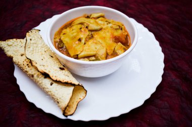 Papad ki sabji Hindistan 'ın kuzey batısında rajasthani ve gujarati eyaletlerinden gelen bir Hint mutfağı. Geleneksel köri tabağı ve kaşıkla servis edilir. Desenli arkaplan kestanesi