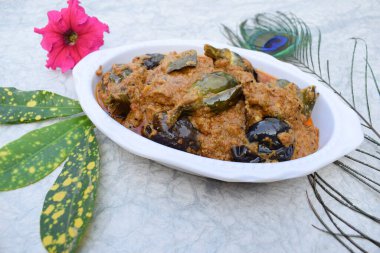 Hint usulü brinjal veya patlıcan soslu baharatlı köri. Beyaz arka planda dekore edilmiş kase.