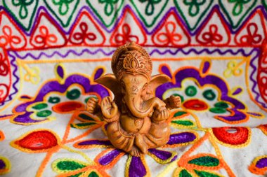 Güzel Lord Ganesha evde oturan sevimli putperest Pooja duası işlemeli motif çok renkli dekorasyon arka planıyla.