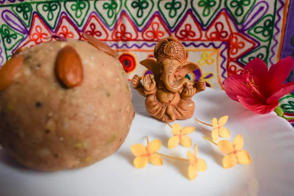 Güzel Lord Ganesha evde oturan sevimli putperest Pooja duası işlemeli motif çok renkli dekorasyon arka planına sahip. Prasad of buğday atta laddu ile sunuldu