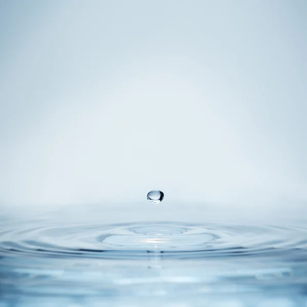 Goccia d'acqua che cade su una superficie liquida — Foto Stock