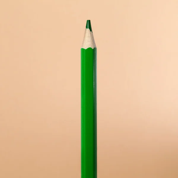 Lápis de cor verde sobre fundo bege — Fotografia de Stock