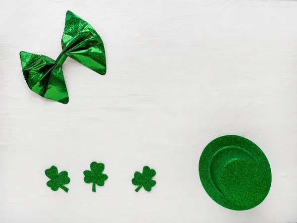 Trébol de trébol y sombrero verde y pajarita sobre un fondo claro, un símbolo de la fiesta irlandesa del Día de San Patricio.. — Foto de Stock