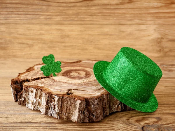 Trébol de trébol y sombrero verde en una mesa de madera, símbolo de la fiesta irlandesa del Día de San Patricio. — Foto de Stock