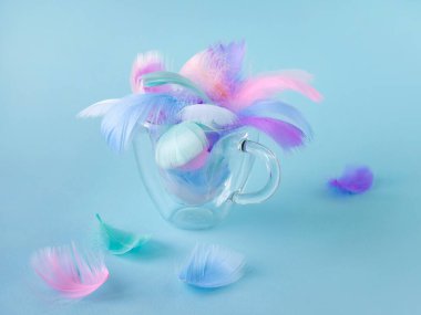 Renkli pastel renkler şeffaf cam bir camda yumuşak dekoratif kuş tüyleri. yumuşak odak