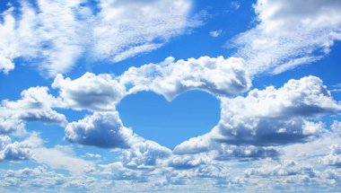 Beyaz bulutlu mavi gökyüzü, aşk temalı arka plan. Açık mavi gökyüzü, kalp şeklinde bulutlar ve metin için yer var..