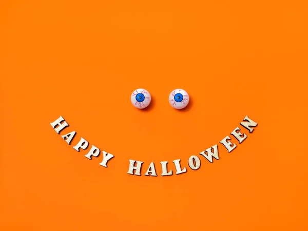Τρομακτικά και αστεία μάτια και Happy Halloween επιγραφή σε πορτοκαλί φόντο, αντιγράψτε το χώρο, επίπεδη διάταξη, κορυφαία προβολή — Φωτογραφία Αρχείου