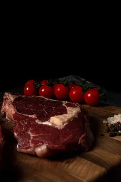 Filete de ternera de mármol crudo en una tabla de cortar de madera — Foto de Stock