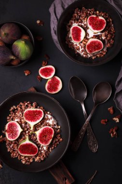 Tahıl gevreği ve incirle kahvaltı. Siyah tabaklar ve taze ve sağlıklı bir kahvaltı. Meyveli sağlıklı yemek.