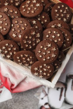 Kutuda çikolatalı kurabiyeler. Yıldızlı kurabiyeler. Yeni yıl tatlıları. Karda kurabiyelerle dolu bir kutu.