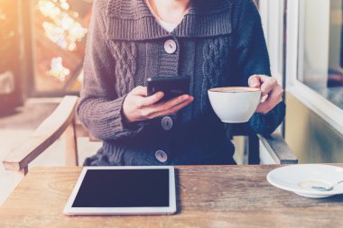 kahve dükkanı ve yumuşak ışık Smartphone kullanan kadın