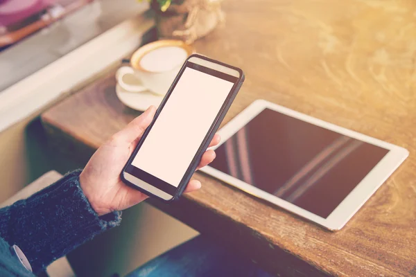 Frau spielt Smartphone und trinkt Kaffee mit Vintage-Ton. — Stockfoto