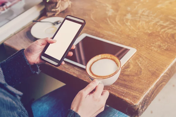 Hand vrouw met behulp van smartphone in koffie shop en zacht licht — Stockfoto