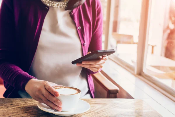 Donna che utilizza smartphone in caffetteria con tono vintage . — Foto Stock