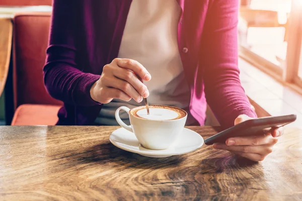 Vrouw met behulp van smartphone in de koffieshop met vintage Toon. — Stockfoto