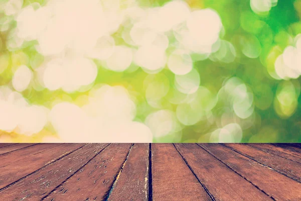 Abstrakte verschwommene grüne Bokeh und Holz Tisch Hintergrund — Stockfoto