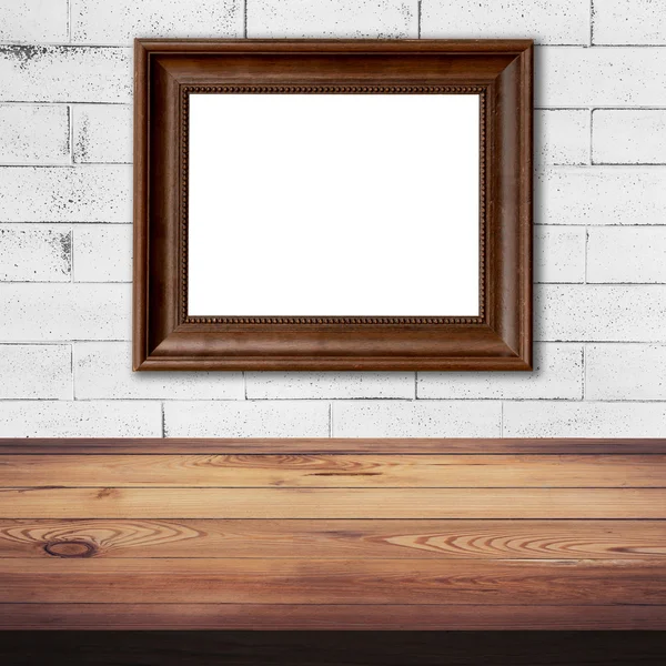 Rahmenbild auf weißer Ziegelwand und Holztischhintergrund — Stockfoto