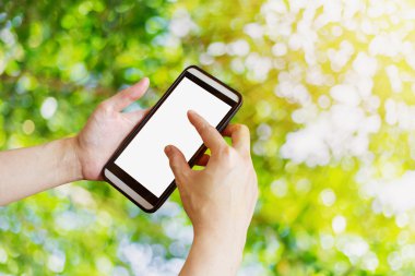 Bokeh ve güneş ışığı ile bahçede telefon kullanan el kadın.,