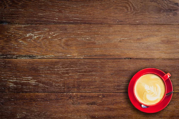 Rote Kaffeetasse auf altem Holzhintergrund mit Platz. — Stockfoto