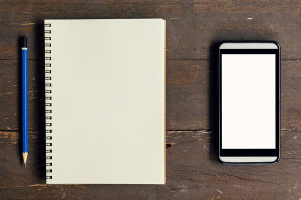 Draufsicht über Notizbuch und Bleistift mit Telefon auf Holztisch — Stockfoto