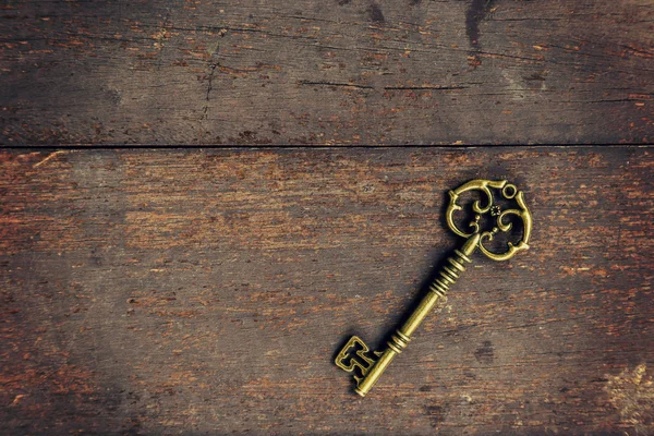 Antigua llave vintage sobre fondo de textura de madera con espacio — Foto de Stock