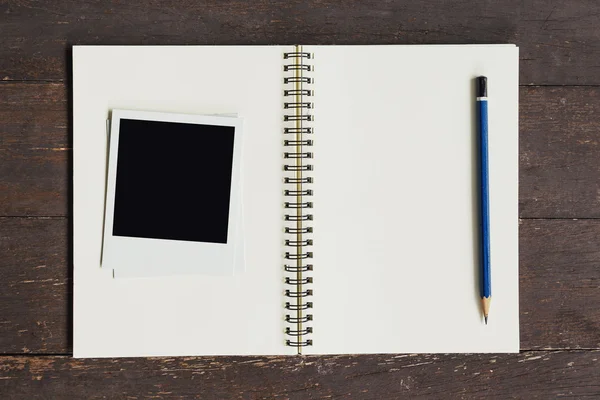 Frame photo and brown book on wood table background. — Stock Photo, Image