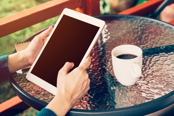 asian woman using tablet on table and coffee in garden with vint