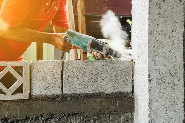 Man worker electric drill make cement pole structure of home