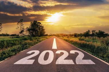 Boş asfalt yol ve yeni yıl 2022 konsepti. 2022 hedeflerine giden boş bir yolda gün batımına doğru sürüyorum..