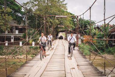 Okuldan geri tozlu bir yolda üzerinde 24 Ekim 2014 yılında Vang Vieng, Laos.Around köyleri orada Bisiklete binme genç kimliği belirsiz erkek yetişkinlere göre daha fazla çocuk vardır.