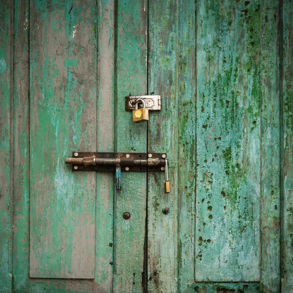 Grunge-Tür mit grünem Doppelschloss und Hintergrund. — Stockfoto