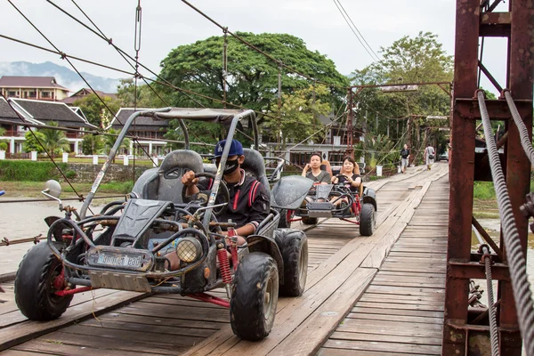 24 Ekim 2014 yılında Vang Vieng, Laos üzerinde kırsal bir yolda araba sürüş bir kimliği belirsiz turist. Vang Vieng bir turizm odaklı Laos, Nam şarkı Nehri üzerinde yalan yeridir. — Stok fotoğraf