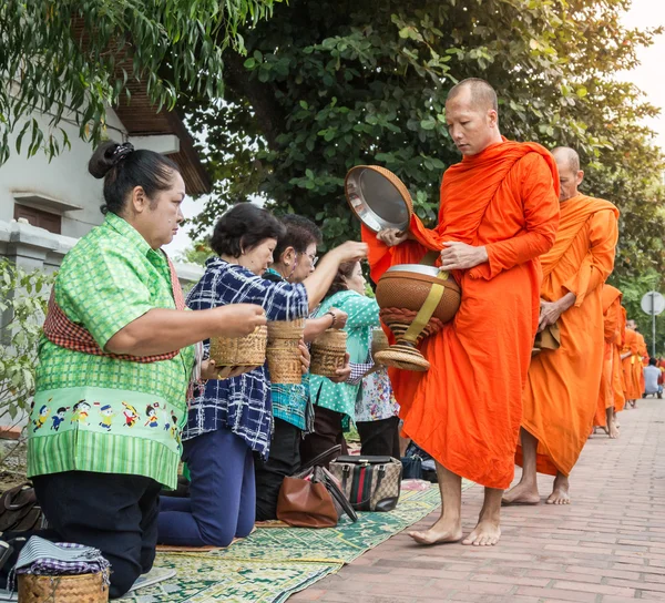 Monjes no identificados caminan para recoger limosnas y ofrendas el 27 de octubre de 2014 Laos. Esta procesión se lleva a cabo todos los días en Luang Prabang por la mañana temprano . —  Fotos de Stock