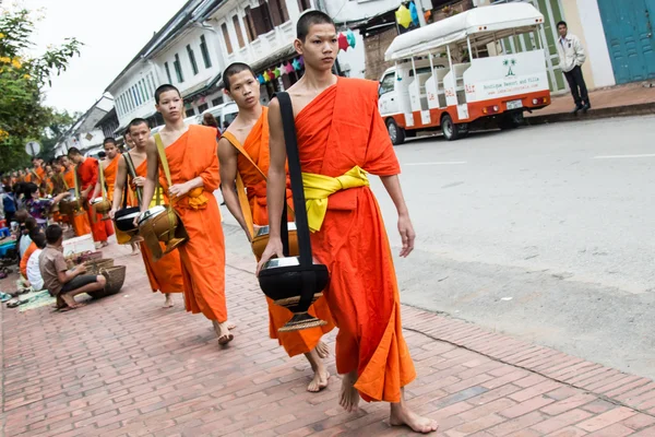 Unidentified monks walk to collect alms and offerings on October 27, 2014 Laos. This procession is held every day in Luang prabang in the early morning. — Stock Photo, Image